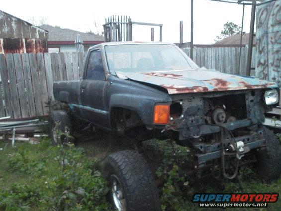 Rusty 1988 Toyota Hilux 3q-front view with missing grille and hood