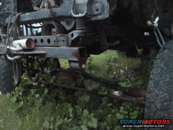 Undercarriage of a vehicle showing suspension components and frame. Tires are visible