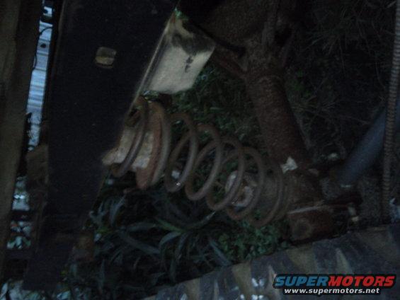 close-up of rusty coil spring and shock absorber on a vehicle's suspension