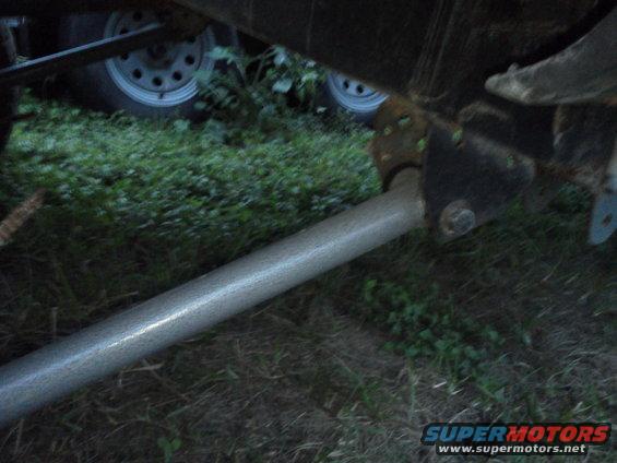 Trailer hitch assembly with suspension components and tires visible in grass