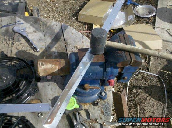 Electric fan and metal strip being worked on in a vise