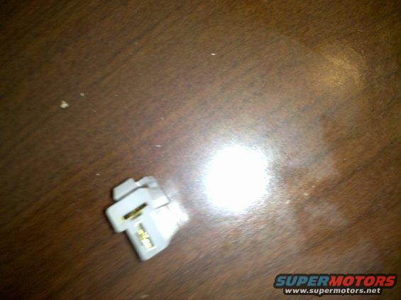 White electrical connector with gold contacts on a wooden surface