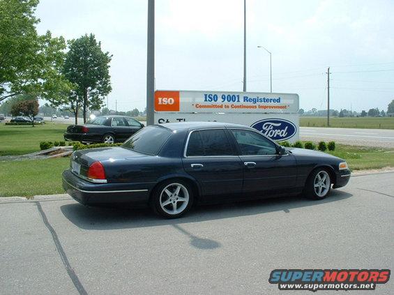 Dark blue 2000 Ford Crown Victoria parked near a Ford dealership sign