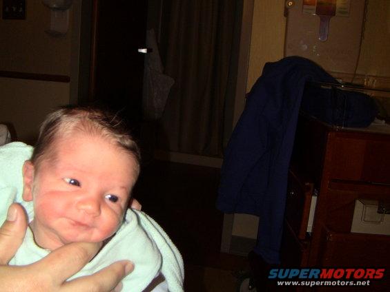 baby wrapped in a light blue blanket, held by a hand