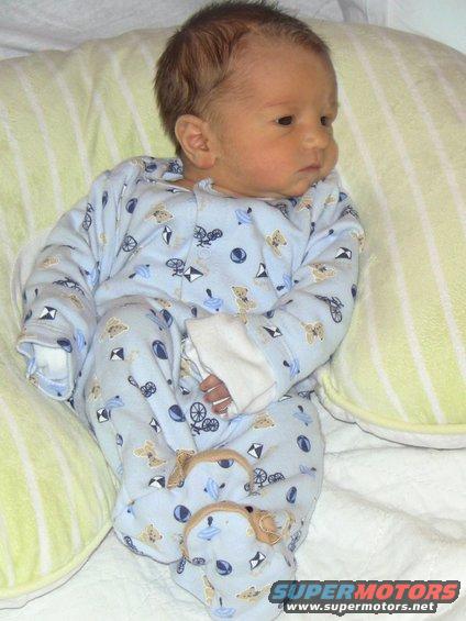 Baby in blue pajamas with teddy bears and toy drawings