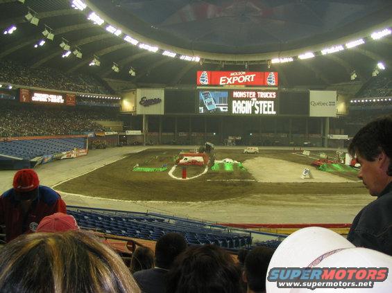 Monster trucks arena with dirt track, ramps, and stadium seating