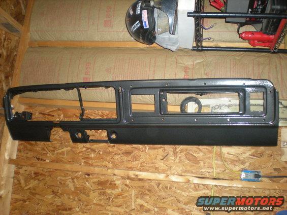 Black dashboard panel with rectangular openings for gauges and radio