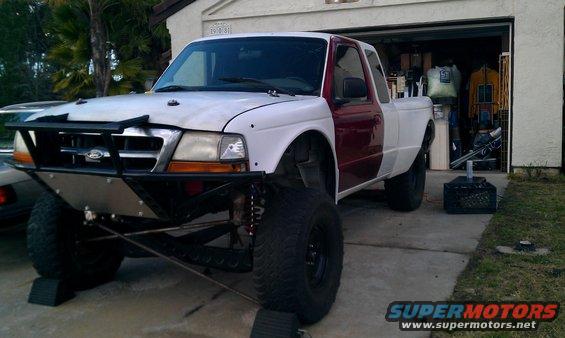 1992 Ford Ranger pickup truck with custom front bumper and lifted suspension, parked in driveway