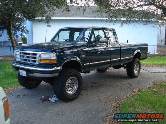 Dark green Ford F-250 pickup truck with lifted suspension and aftermarket wheels