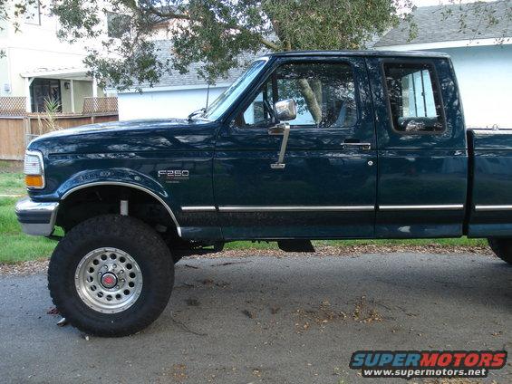 Side view of dark green 1994 Ford F-250 pickup truck with chrome trim