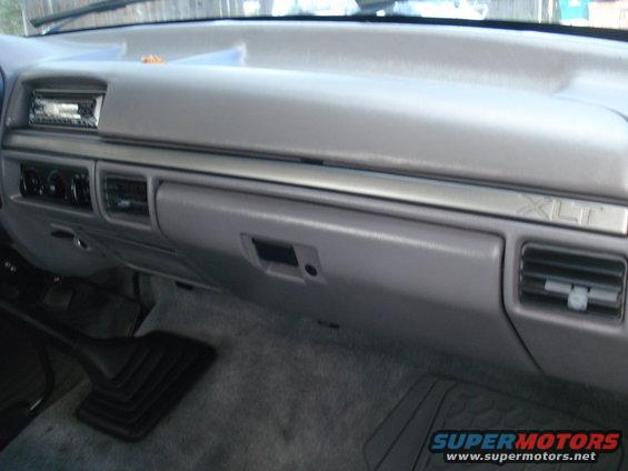 Interior shot of a truck's dashboard, showing the glove box, radio, and air vents. XLT trim is visible