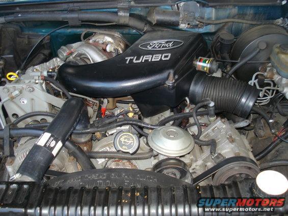 Ford 7.3L IDI Turbo diesel engine bay with "Ford TURBO" air intake cover. Oil cap visible