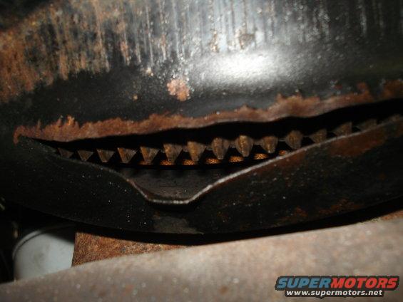 Close-up of rusted metal part with visible teeth and a Supermotors.net watermark
