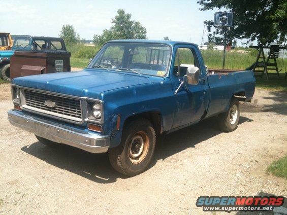 Blue 1973 Chevrolet C/K Pickup truck, front quarter view, showing chrome bumper and grille