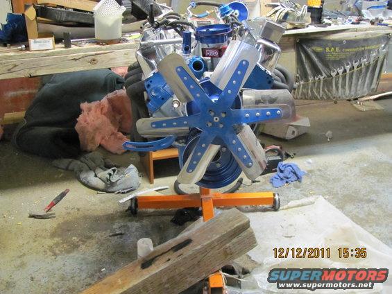 Engine on an orange stand, with a blue fan shroud and silver fan blades