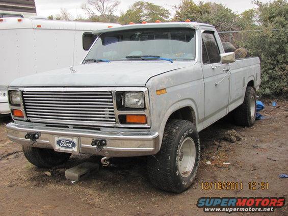 Light-colored pickup truck with chrome grille and Ford badge. Visible date stamp 12/18/2011