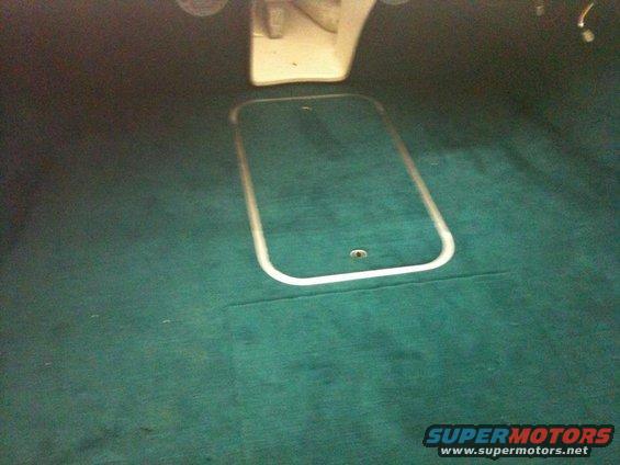 Boat interior with teal carpet and a rectangular hatch