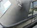 1985 Ford Mustang - The convertible top of a 1985 Ford Mustang shows significant wear and tear, with visible damage and some text on the rear window.