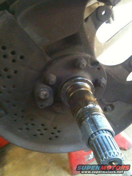 Close-up of a vehicle's front wheel hub assembly with splined axle shaft