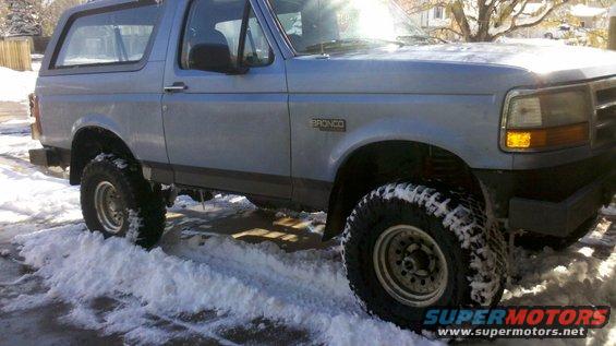1996 Ford Bronco with lifted suspension driving in snow
