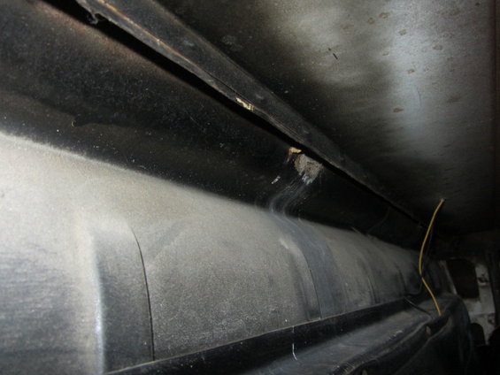 Dusty black interior shelf with a yellow wire
