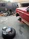 1994 Ford Bronco - Two Ford Broncos are undergoing repairs in a driveway, one being worked on by a mechanic.