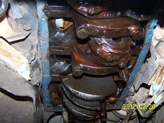Engine crankshaft with oil pan removed, showing bearings and connecting rods. Date stamp 2012/02/20