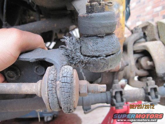 Close-up of a severely damaged ball joint and tie rod ends on a vehicle's suspension system