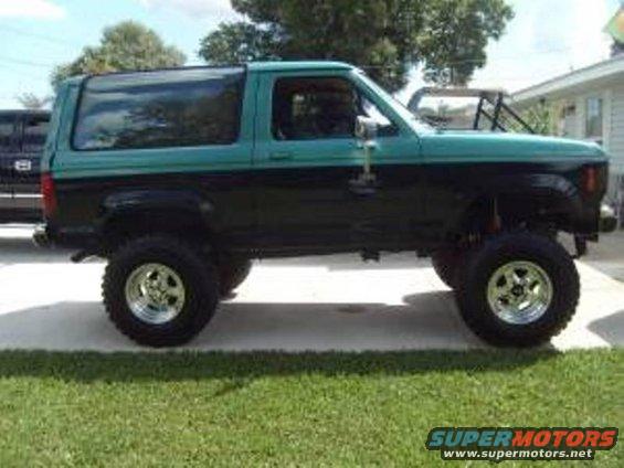 Two-tone green and black Ford Bronco II with lifted suspension and aftermarket wheels
