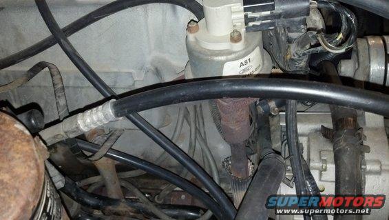 Engine bay with hoses, wires, and a part labeled A51 Ford