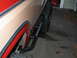1984 Ford Bronco - 1984 Ford Bronco side profile with aftermarket rock sliders and red fender flares.