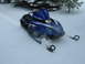 1987 Polaris Indy 600 - A blue snowmobile with SRX graphics is seen in the snow, kicking up powder.