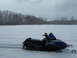 1987 Polaris Indy 600 - A blue Yamaha SRX snowmobile sits in a snow-covered field under a cloudy sky.