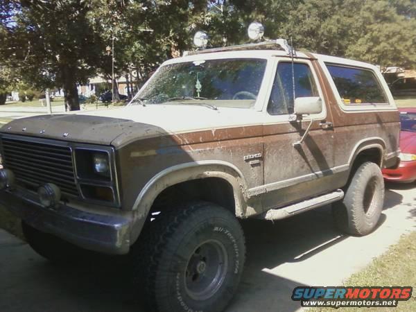Brown and white SUV with off-road lights, seen from a 3/4 front angle