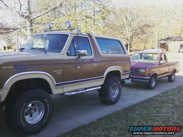 Two-tone brown Ford Bronco and red Ford Ranger parked side-by-side