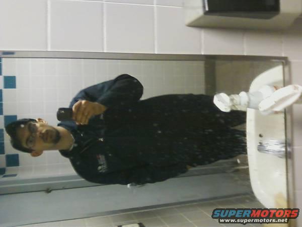 Man taking a mirror selfie in a bathroom, reflecting a sink and faucet