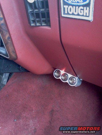 Triple cigarette lighter installed on red dashboard near air vent. Ford Tough sticker visible