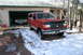 1990 Ford Bronco - A red 1990 Ford Bronco 4x4 is parked in front of a garage, with another vehicle visible inside.
