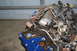1990 Ford Bronco - Engine assembly with hoses and wiring, mounted on a blue stand.