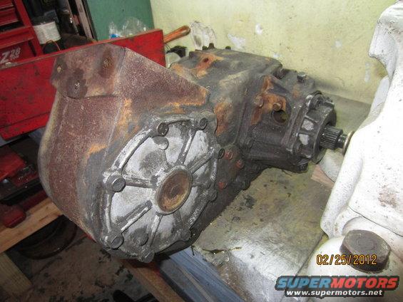 Rusty NP205 transfer case on a workbench, showing bolted housing and output shaft