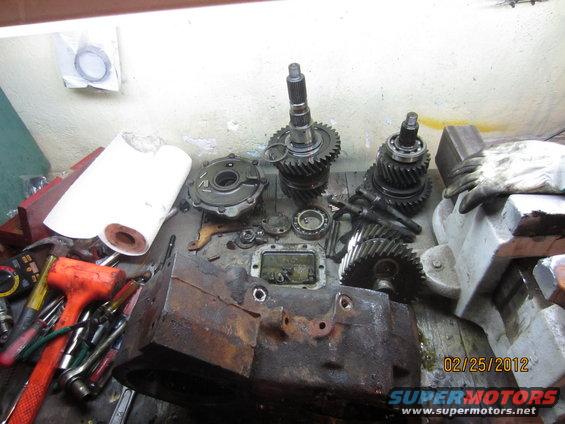 Disassembled transfer case and gears on a workbench with tools. Date stamp 02/25/2012
