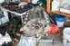 1990 Ford Bronco - Engine block on stand, surrounded by tools and various containers. Supermotors.net logo is present.