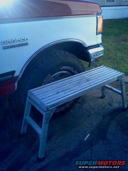 Side view of a 1989 Ford Bronco with a step stool in front of the rear tire