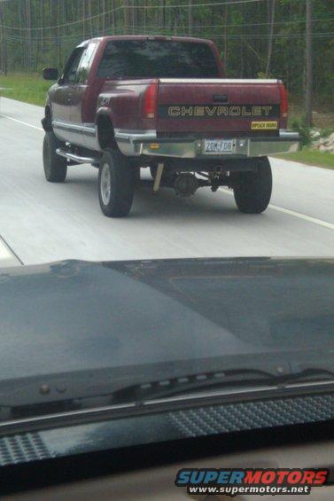 Maroon Chevrolet pickup truck, rear view, lifted suspension