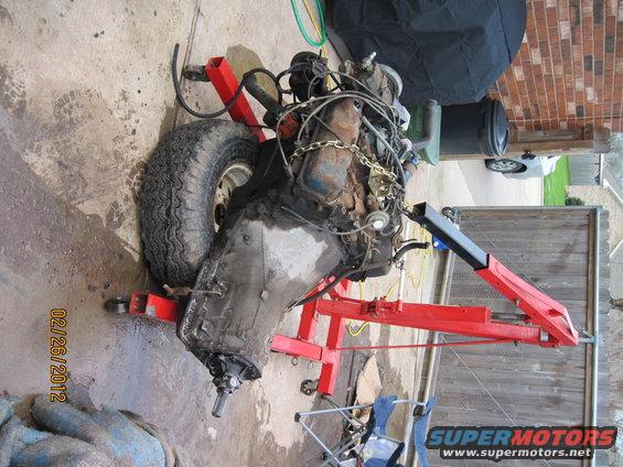Engine and transmission on an engine stand with a tire next to it