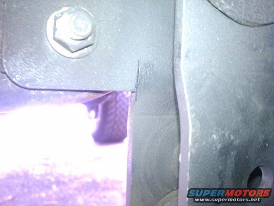 Close-up of vehicle frame with a tire visible through an opening