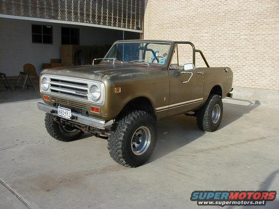 Brown International Harvester Scout II with off-road tires, lifted suspension, and roll cage parked on concrete