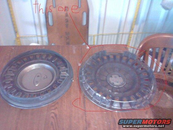 Two hubcaps on a wooden table. One has a Ford logo