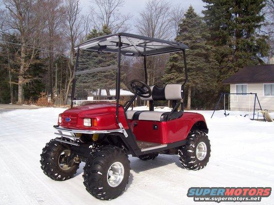 red golf cart with big tires in the snow
