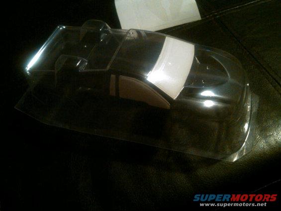 Clear plastic RC car body shell with a white stripe on the windshield area